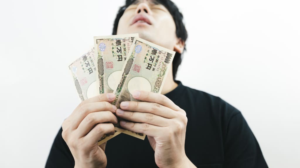 お金を持って上を向く男性